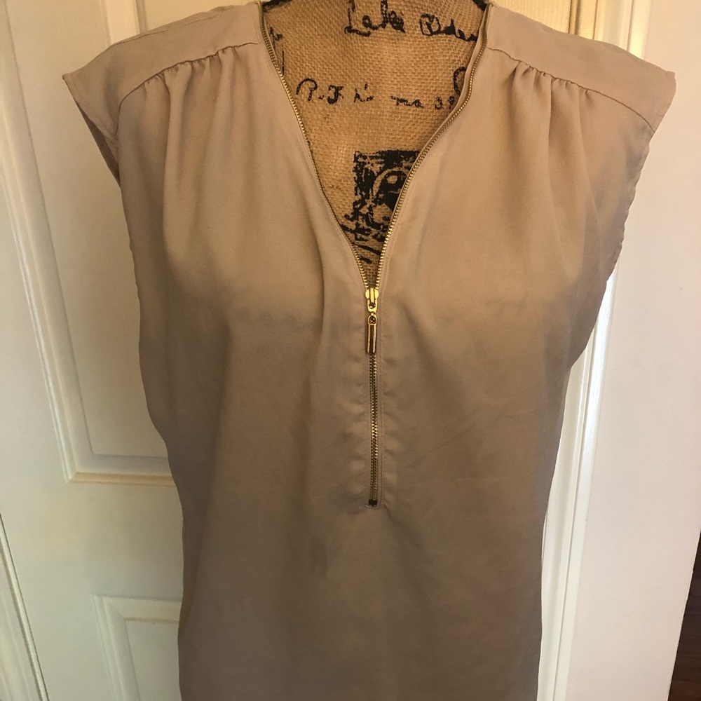 Sleeveless Tan shirt with gold zipper detail.